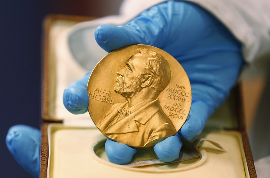 FILE- A national library employee shows the gold Nobel Prize medal awarded to the late novelist Gabriel Garcia Marquez, in Bogota, Colombia. The beginning of October means Nobel Prize season. That is  ...