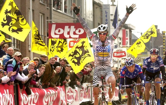 BRU61 - 20020410 - WEVELGEM, BELGIUM : Italian cyclist Mario Cipollini (L) of team Acqua &amp; Sapone celebrates on the finish line after winning for the third time the Gent - Wevelgem cycling race, W ...