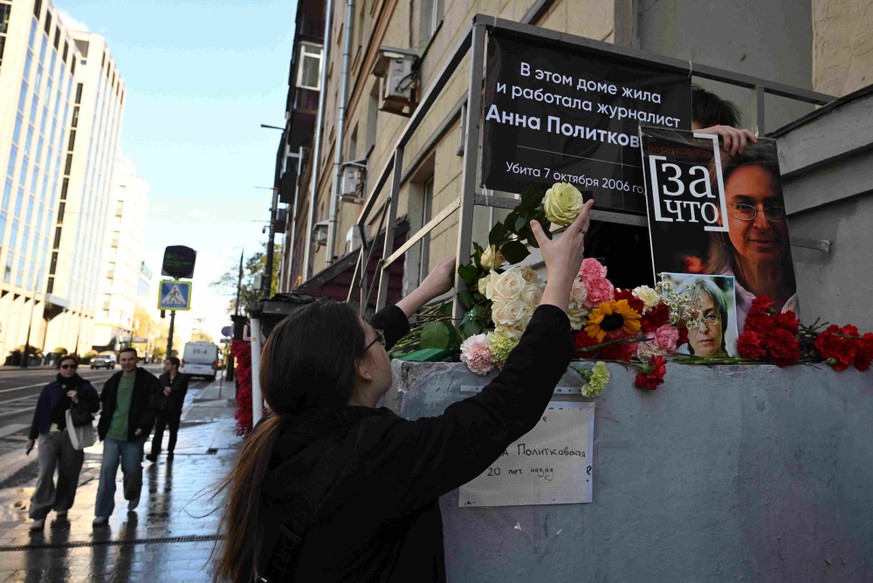 Une femme dépose des fleurs devant un mémorial improvisé en hommage à la journaliste russe assassinée Anna Politkovskaïa, devant son immeuble à Moscou, le 7 octobre 2026, à l'occasion du 20e anni ...
