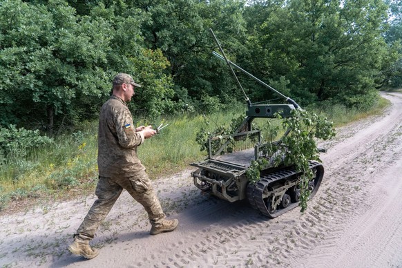 Un spécialiste ukrainien pilote un drone terrestre conçu pour le transport.