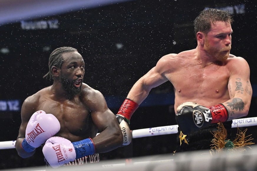 Terence Crawford, left, punches Canelo Alvarez during an undisputed super middleweight championship boxing match in Las Vegas, Saturday, Sept. 13, 2025. (AP Photo/David Becker)
Canelo Alvarez,Terence  ...