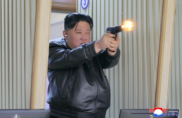 In this photo provided by the North Korean government, its leader Kim Jong Un tries out a new pistol at a factory producing pistols and other light arms at an undisclosed place in North Korea Wednesda ...