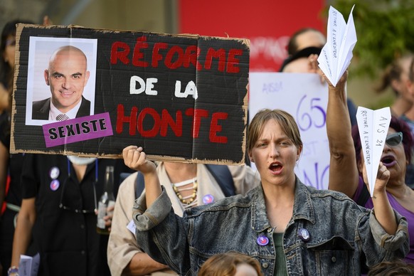 Des personnes lancent des avions en papier et brandissent des pancartes lors d&#039;une manifestation contre AVS 21 et contre l&#039;augmentation de la TVA en marge d&#039;une conference d&#039;Alain  ...