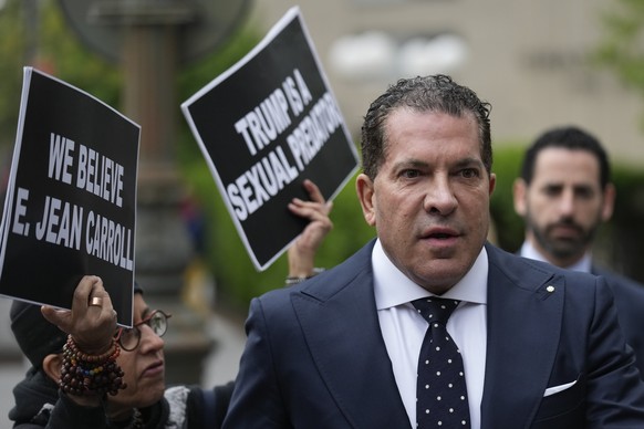 Joe Tacopina, a lawyer representing former President Donald Trump, arrives to federal court as Laurie Arbeiter, left, holds signs protesting Trump in New York, Thursday, April 27, 2023. A writer has t ...