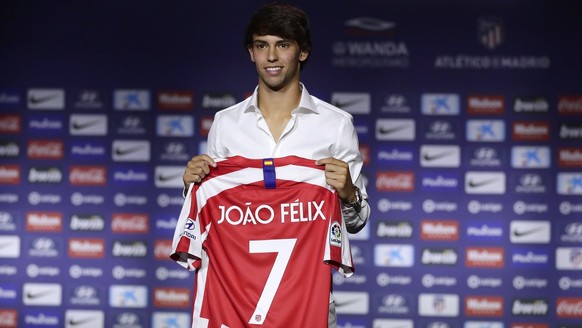 Atletico Madrid's new signing soccer player Joao Felix holds his new jersey as he poses for media during his official presentation at the Wanda Metropolitano Stadium in Madrid, Monday, July. 8, 2019.  ...
