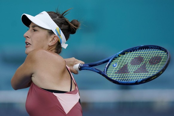 Belinda Bencic of Switzerland wears a ribbon on her visor in the colors of the Ukrainian flag as she returns a shot to Daria Saville of Australia, during the Miami Open tennis tournament, Tuesday, Mar ...