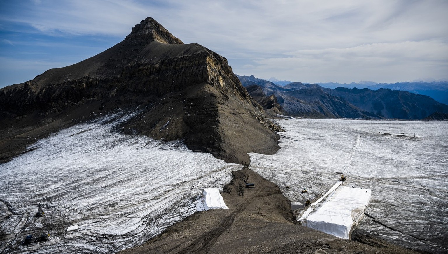 Wanderer gehen am Dienstag, den 13. September 2022, auf dem Gebiet von Glacier 3000 oberhalb von Les Diablerets an der Trennung des Scex Rouge-Gletschers vom Tsanfleuron-Gletscher vorbei, wodurch der  ...