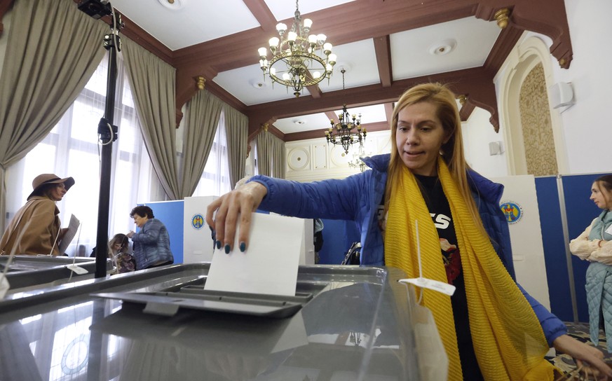 epa11671006 A Moldovan woman residing in Romania casts her vote at a polling station located in downtown Bucharest, Romania, 20 October 2024. Moldova holds a presidential election and a referendum on  ...
