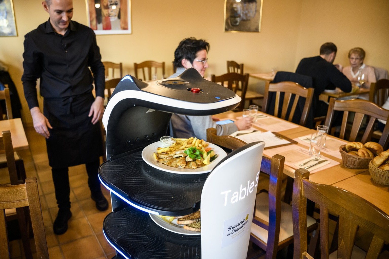 Le robot serveur transporte des plats pour les clients dans le restaurant de la Brasserie de Chauderon le vendredi 11 novembre 2022 a Lausanne. (KEYSTONE/Jean-Christophe Bott)