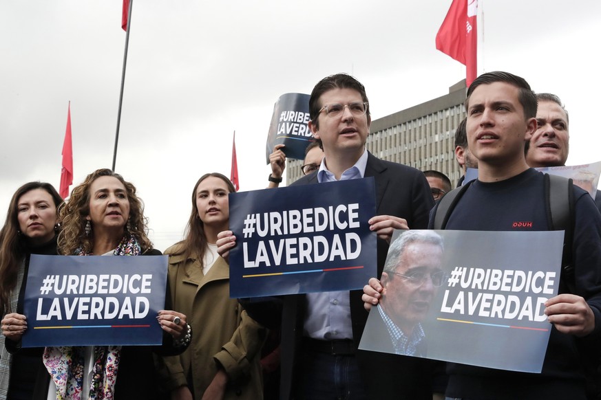 epa12075592 Colombian Senator Miguel Uribe (2-R) and supporters of former Colombian President Alvaro Uribe hold signs outside the Paloquemao courthouse in Bogota, Colombia, 05 May 2025. Former Colombi ...