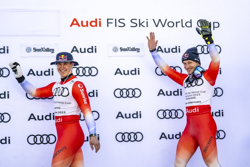 Marco Odermatt of Switzerland, right, celebrates with the men's Downhill discipline leader crystal globe trophy with second placed Franjo von Allmen of Switzerland, left, during the podium ceremo ...