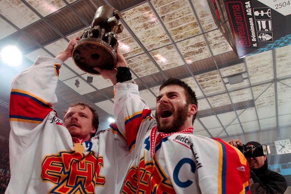 Les Biennois Kevin Schlaepfer et Rene Furler tiennent la coupe remportee lors du match de finale de playoff LNB entre HC Bienne et HC Sierre-Anniviers, ce mardi 23 mars 2004 a Bienne. (KEYSTONE/Sandro ...