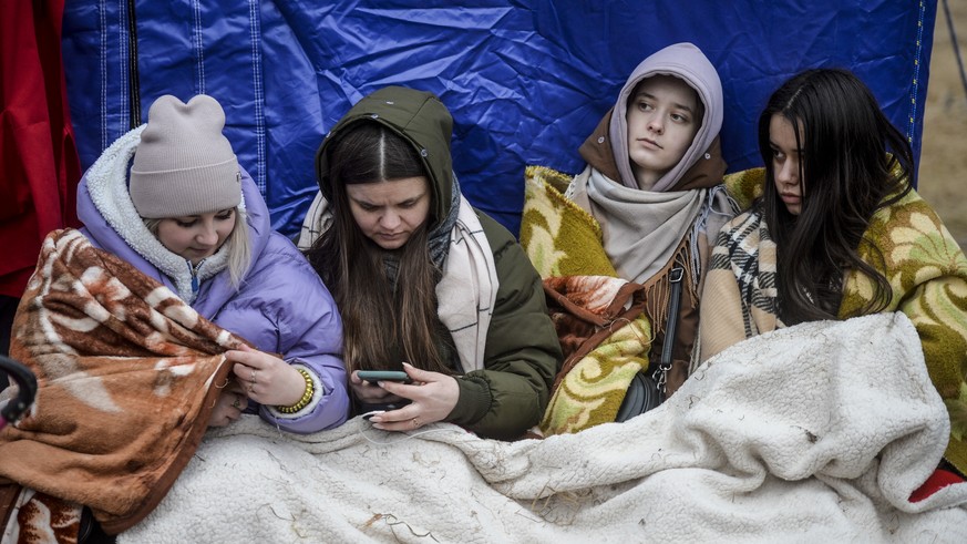 Refugees that fled the conflict from neighbouring Ukraine, await for transportation at the Romanian-Ukrainian border, in Siret, Romania, Sunday, Feb. 27, 2022. Since Russia launched its offensive on U ...