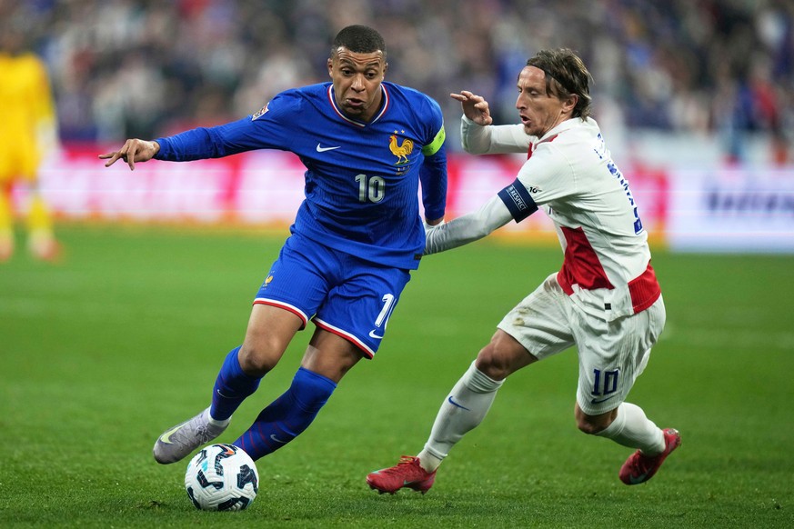 FILE - France's Kylian Mbappe, left, is challenged by Croatia's Luka Modric during the UEFA Nations League quarterfinal second leg soccer match between France and Croatia, at the Stade de Fr ...
