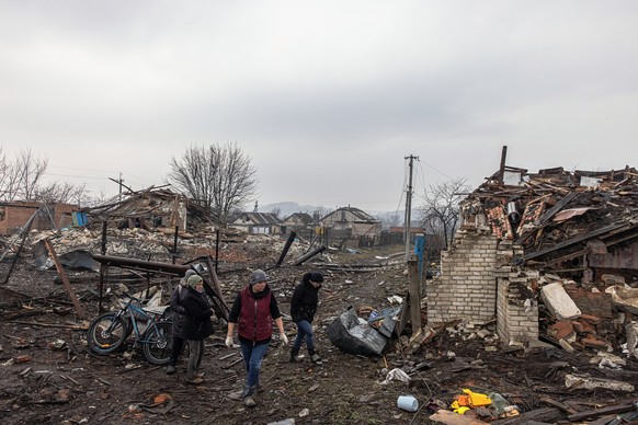 epaselect epa09861069 Taisia (C), walks with her friends next to her house destroyed during the Russian invasion, in Boromlia village, at Trostyanets district which was recaptured by the Ukrainian arm ...