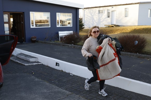 A resident from the town of Grindavik, Iceland, takes some of their belongings from their house Monday Nov. 13, 2023. Residents of Grindavik, a town in southwestern Iceland, have been briefly allowed  ...
