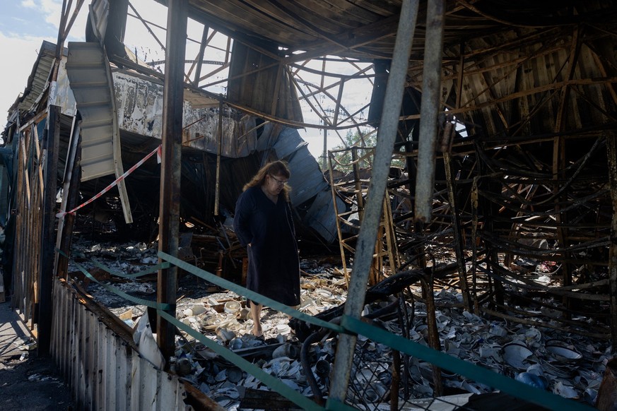(FILES) A woman looks at burnt and broken ceramic items at a damaged street market following Russian strikes in Petrivka neighbourhood in Kyiv on August 9, 2026, amid the Russian invasion of Ukraine.  ...