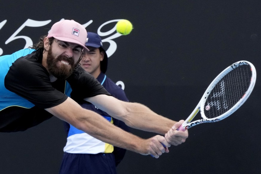 Reilly Opelka of the U.S. plays a backhand return to Tomas Machac of the Czech Republic during their second round match at the Australian Open tennis championship in Melbourne, Australia, Wednesday, J ...