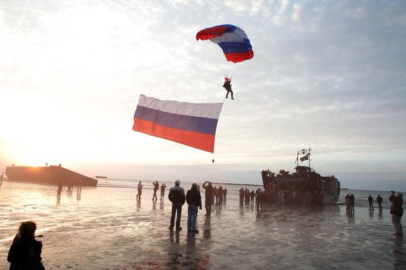 A parachutist with a giant Russian flag jumps onto the beach of Arromanches, western France, Thursday June 5, 2014. World leaders and veterans prepare to mark the 70th anniversary of the invasion this ...