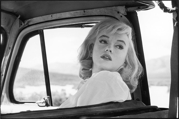 American actress Marilyn Monroe (1926 - 1962) (born Norma Jean Mortensen) glances over her shoulder from the front seat of a car on the set of 'The Misfits,' directed by John Huston, Nevada, ...