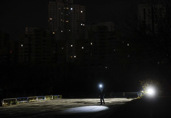 epa12516803 People walk with flashlights on a dark street during an electricity cut-off in Kyiv, Ukraine, Ukraine, 10 November 2025, amid the ongoing Russian invasion. The main target of the Russian s ...