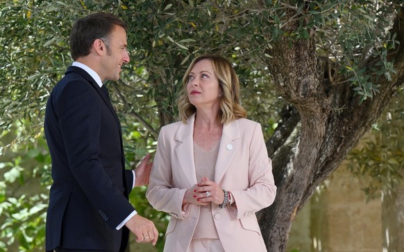 epa11407582 Italy's Prime Minister Giorgia Meloni (R) greets French President Emmanuel Macron (L) during a welcome ceremony for the G7 summit in Borgo Egnazia, southern Italy, 13 June 2024. The 5 ...