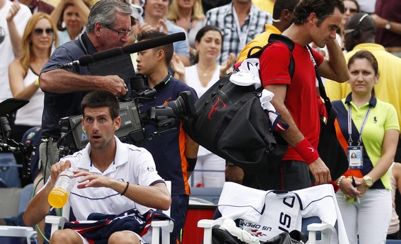 Roger Federer of Switzerland leaves after losing a semifinal match to Novak Djokovic of Serbia, left, at the U.S. Open tennis tournament in New York, Saturday, Sept. 10, 2011. (AP Photo/Charles Krupa)