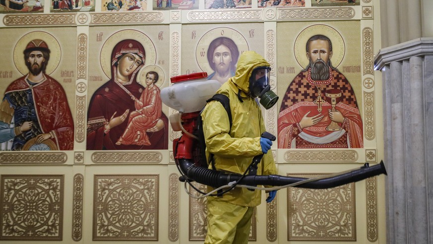 epa09531793 A worker from the Russian Ministry of Emergency Situations wearing a protective suit conducts disinfecting works at Leningradsky Railway Station amid the ongoing coronavirus disease (COVID ...