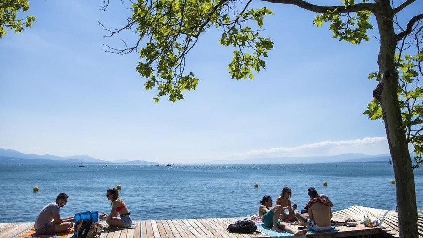 Une separation de distance est visible entre des personnes profitant du soleil sur le deck de la &quot;Jetee de la Compagnie&quot; au bord du lac Leman lors de la crise du Coronavirus (Covid-19) le di ...