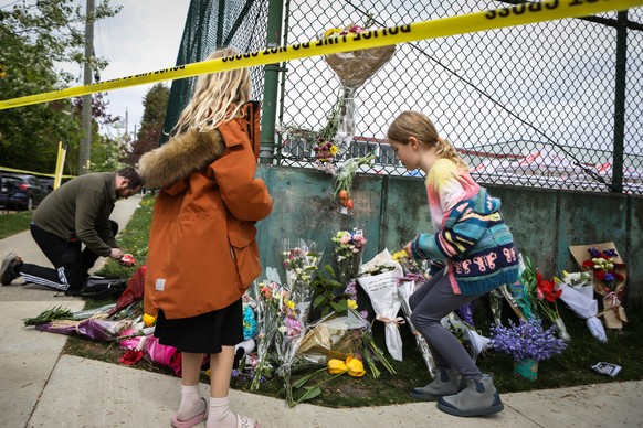 epa12059749 People leave flowers at a make-shift memorial where a car-ramming tragedy took place during a Filipino festival in Vancouver, British Columbia, Canada, 27 April 2025. At least 11 people ar ...
