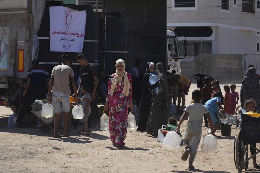 Palestinians carry containers for water at a camp for the displaced in Deir al-Balah, Gaza Strip, Monday, July 7, 2025. (AP Photo/Abdel Kareem Hana)
Israel Palestinians