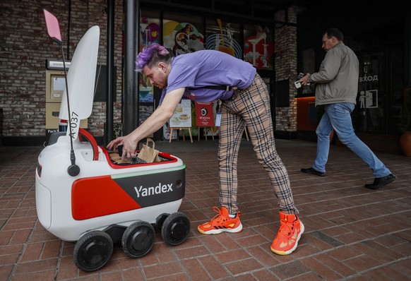 epa09507402 The robot courier Yandex Rover delivers food from Usachevsky market in Moscow, Russia, 05 October 2021. Yandex Rover robot courier ?roduced by the Russian multinational company in the info ...