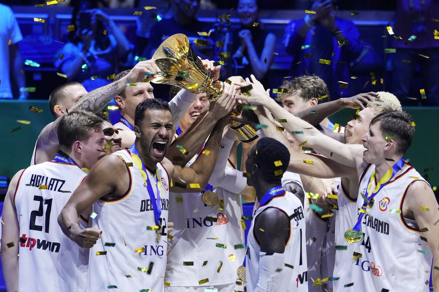 Germany celebrates with the trophy after winning the championship game of the Basketball World Cup against Serbia in Manila, Philippines, Sunday, Sept. 10, 2023. (AP Photo/Michael Conroy)
