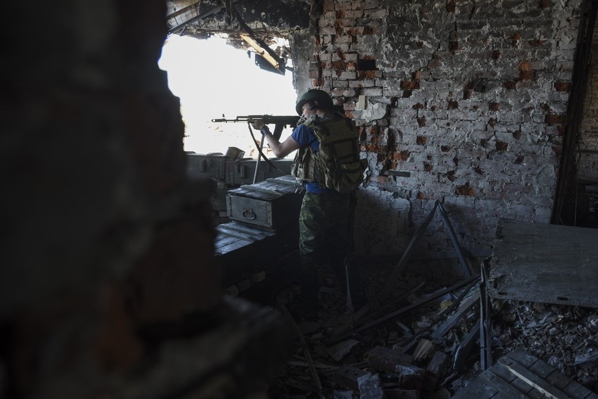 A Russia-backed rebel fires at Ukrainian army positions at Donetsk airport, eastern Ukraine, Tuesday, June 9, 2015. Heavy fighting continue at the frontline at the airport of Donetsk. (AP Photo/Mstysl ...