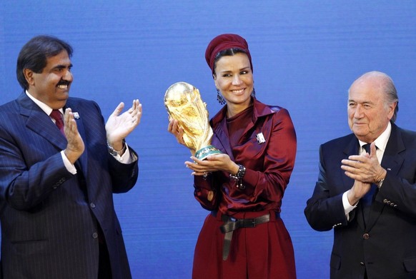 FILE - Sheikh Hamad bin Khalifa Al-Thani, Emir of Qatar, left, and FIFA President Joseph Blatter, right, applaud, as Sheika Mozah bint Nasser al-Misned holds the World Cup trophy, after the announceme ...