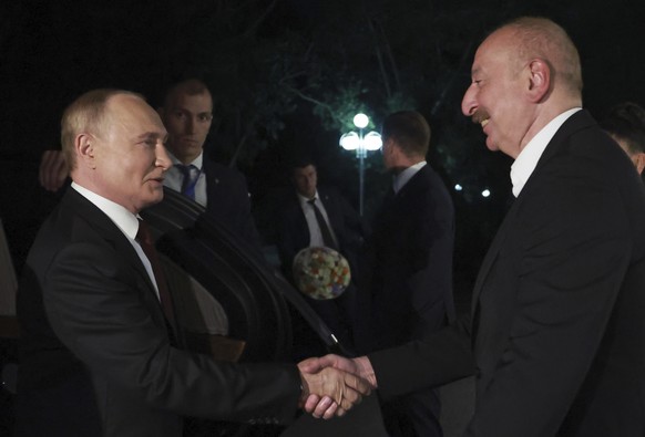 Russian President Vladimir Putin, left, and Azerbaijani President Ilham Aliyev shake hands during their meeting, in Baku, Azerbaijan, Sunday, Aug. 18, 2024. (Vyacheslav Prokofyev, Sputnik, Kremlin Poo ...