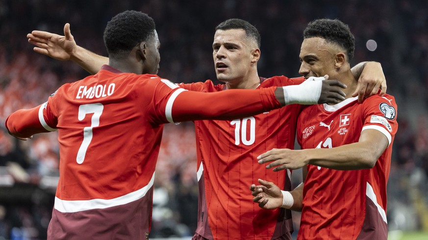 Switzerland&#039;s Breel Embolo, left, celebrates with teammates Granit Xhaka, center, and Dan Ndoye, after scoring to 1:0, during the FIFA 2026 World Cup Group B qualifying soccer match between Switz ...