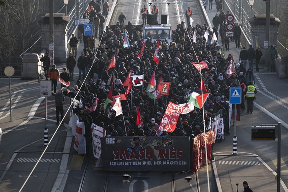 epa11834256 Demonstrators walk between a police escort during a national protest against the World Economic Forum (WEF) with the slogan &#039;Stop the game of the powerful - a beautiful life for all&# ...