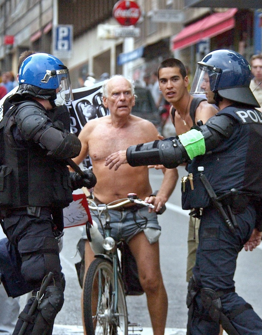 An elderly anti-G-8 protestor negotiates his passage through a line of Swiss riot police in the center of Geneva, Sunday June 1, 2003. Several thousands of anti-globalisation demonstrators arrived to ...