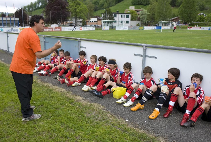 Un coach et ses apprentis footballeurs.