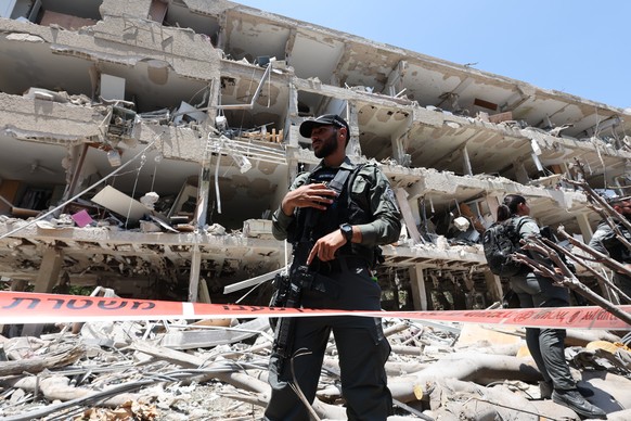 epaselect epa12190668 Israeli emergency teams at the site of an Iranian missile strike on a residential building complex in Tel Aviv, Israel, 22 June 2025. Israel and Iran have been exchanging fire si ...
