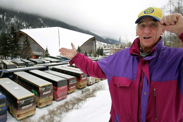 An supporter of Swiss ice hockey club HC Davos points to the ice hockey stadium where more than 50 coaches from all parts of Switzerland are parked at the opening day of the 78th ice hockey Spengler C ...