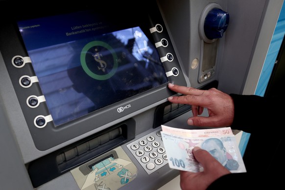 epa10195455 A man adds money into his account with an Is Bank ATM in Istanbul, Turkey, 20 September 2022. The Is Bank stopped using the Russian Mir payment system after Washington, US, warned it could ...