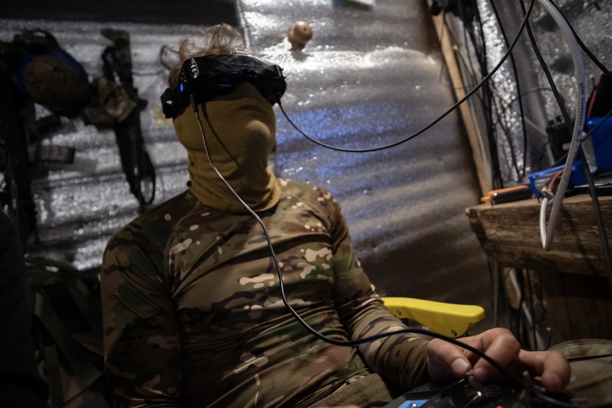 epa12256338 Ukrainian drone pilots belonging to the 20th Lyubart Brigade of the 1st Corps of the National Guard Azov conduct an FPV drone strike mission from inside their trench on the Toretsk frontli ...