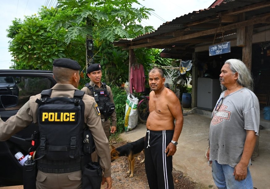 Des policiers tentent de convaincre les villageois d&#039;évacuer une zone où des affrontements entre soldats thaïlandais et cambodgiens ont eu lieu, à Ban Ta Miang, district de Phanom Dong Rak, provi ...