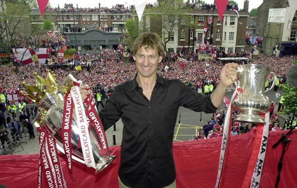 Arsenal captain Tony Adams shows the English Premier League soccer trophy, left, and Football Assocation Cup, to thousands of supporters Sunday, May 12, 2002. The Arsenal soccer squad went to London&# ...