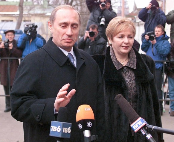 epa07764422 (FILE) - Russian acting President Vladimir Putin (L) gestures towards journalists as he arrives with his wife Lyudmila (R) to cast his vote in Russian presidential elections at a polling s ...