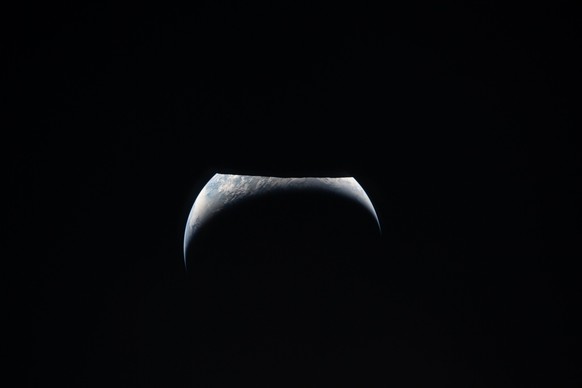 In this image provided by NASA, the Artemis II crew captured this view as the Earth moves out from behind the Moon, top, during a lunar flyby, Monday, April 6, 2026. NASA via AP).NASA Artemis Moonshot