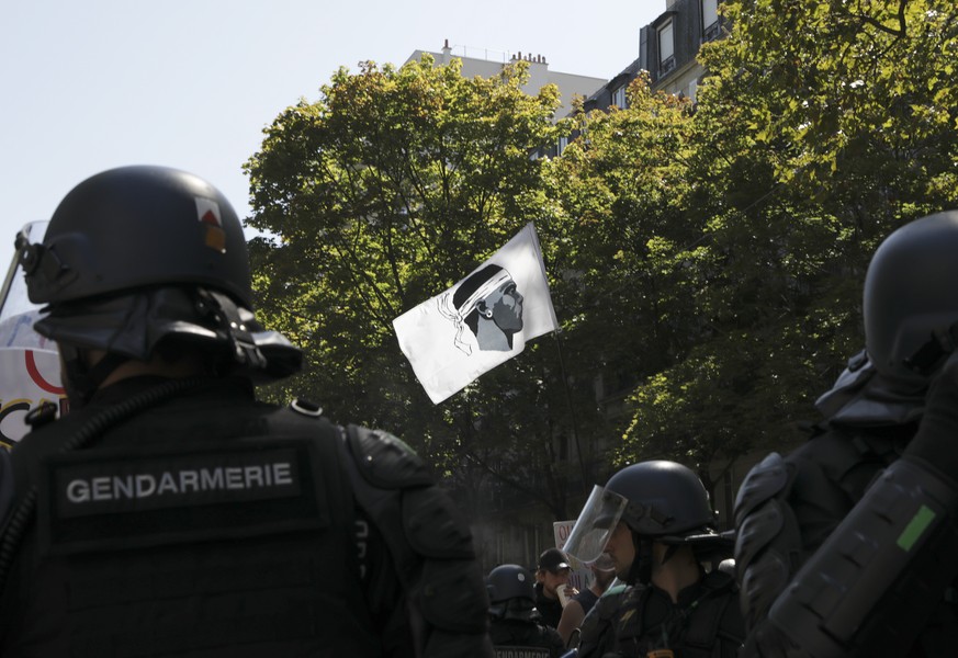 A demonstrator waves the flag of Corsica as they march with others in Paris on Saturday, Aug. 14, 2021. Protesters are rallying in Paris and other parts of France as they continue to show their opposi ...