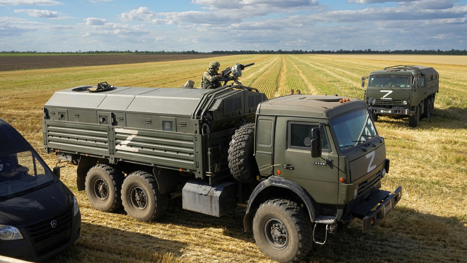 FILE - During a trip organized by the Russian Ministry of Defense, a Russian soldier stands guard atop a military truck as foreign journalists observe farmers at the Voznesenka-Agro farm harvest grain ...